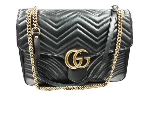 Black quilted leather Gucci handbag with gold double-G logo and chain strap.