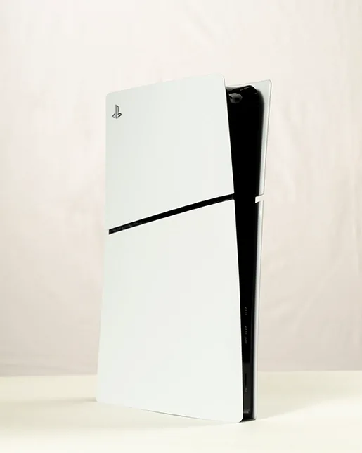 PlayStation 5 gaming console standing upright on a light-colored surface with a white and black design.