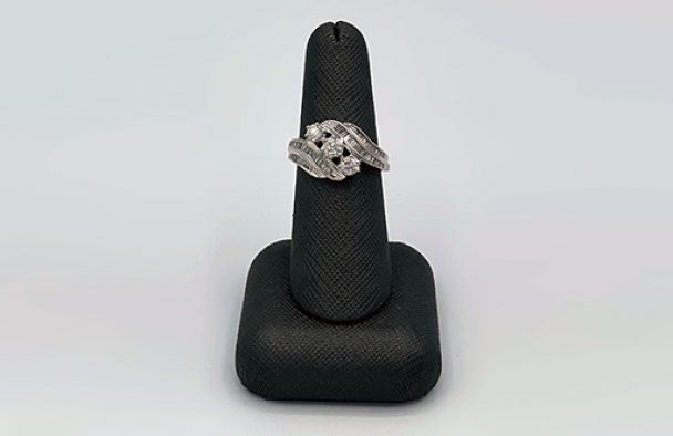 A lady's ring on display with a grey background.
