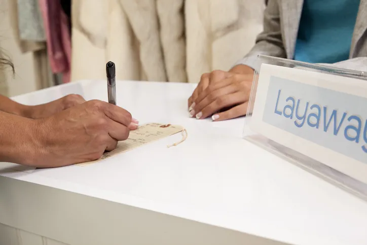An EZPAWN team member is writing on a layaway ticket.